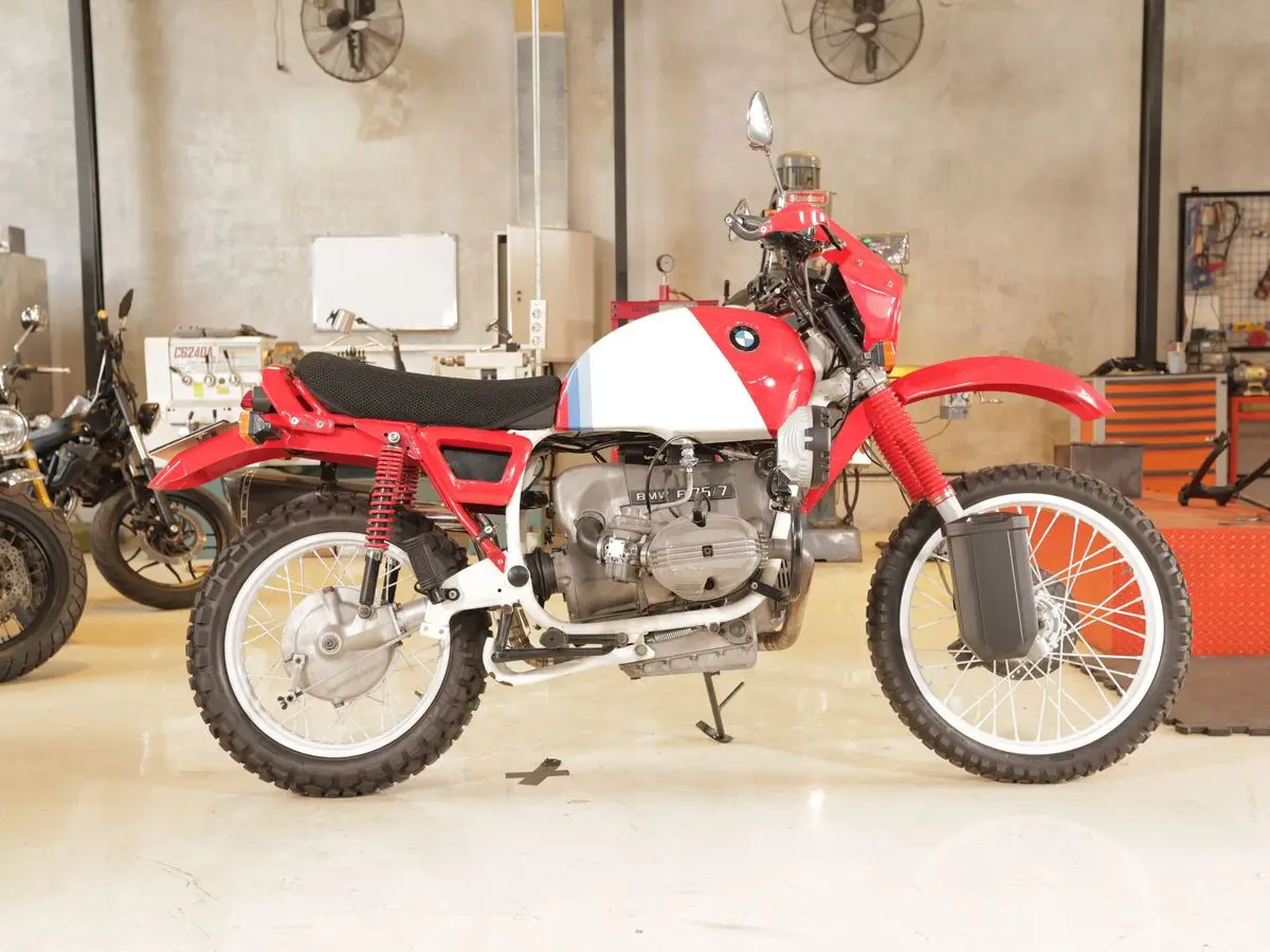 A red and white BMW R80 G/S side-on in the workshop