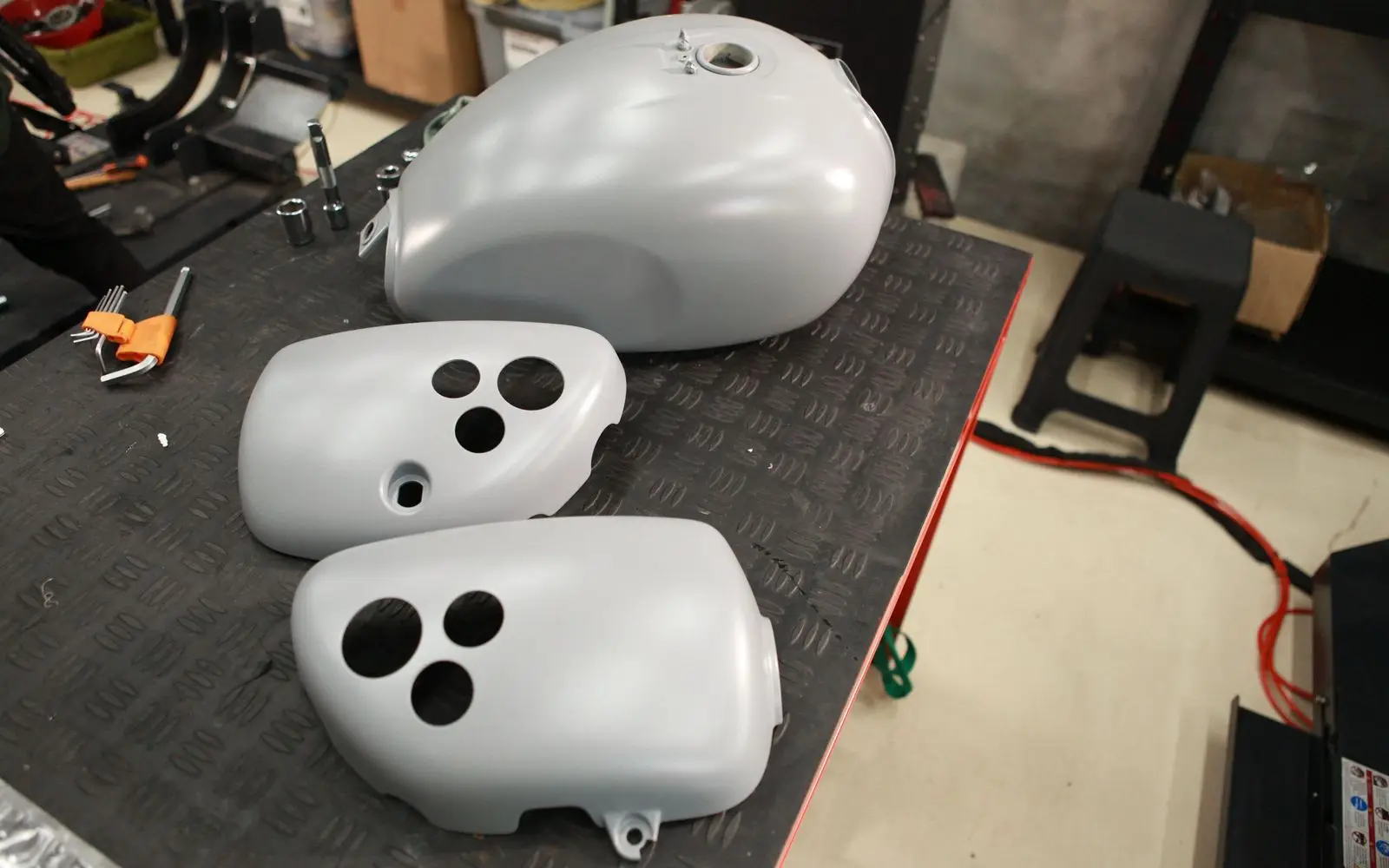 A primed tank and side covers on the bench