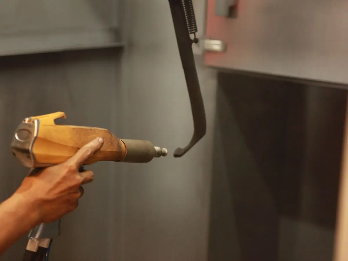 A powder coating gun and a hanging part, close